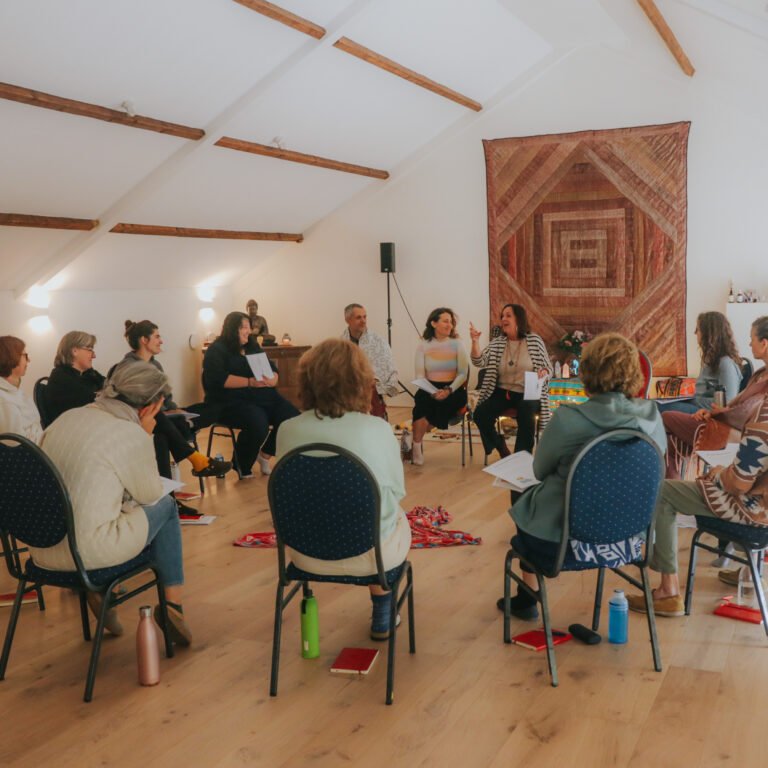 Group of people sitting in a circle for an event.